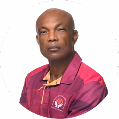 Portrait of a bald man wearing a maroon and pink shirt with an embroidered logo.