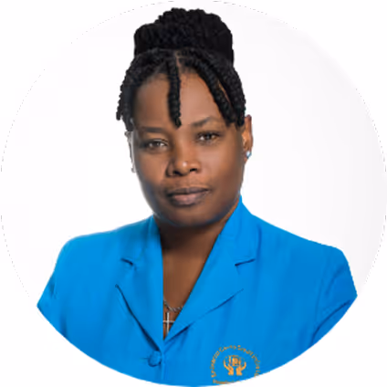 Woman with braided hair styled in an updo, wearing a blue blazer with a small emblem on the left side.